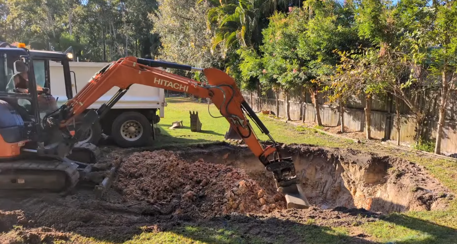 Excavator digging a pool in a backyard